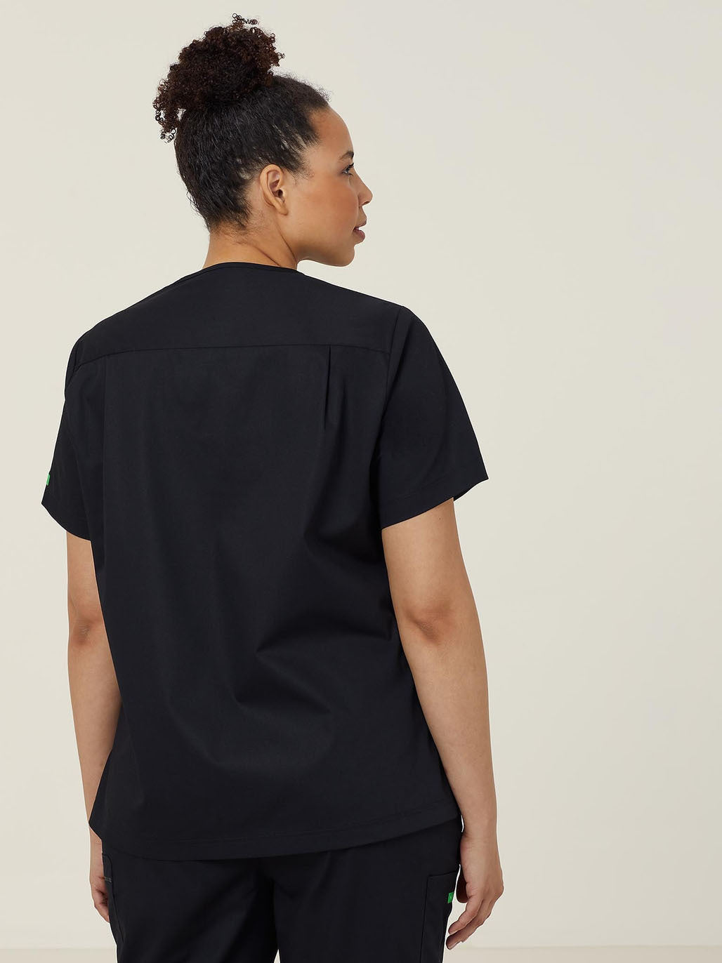 A woman in a black scrub suit from behind.